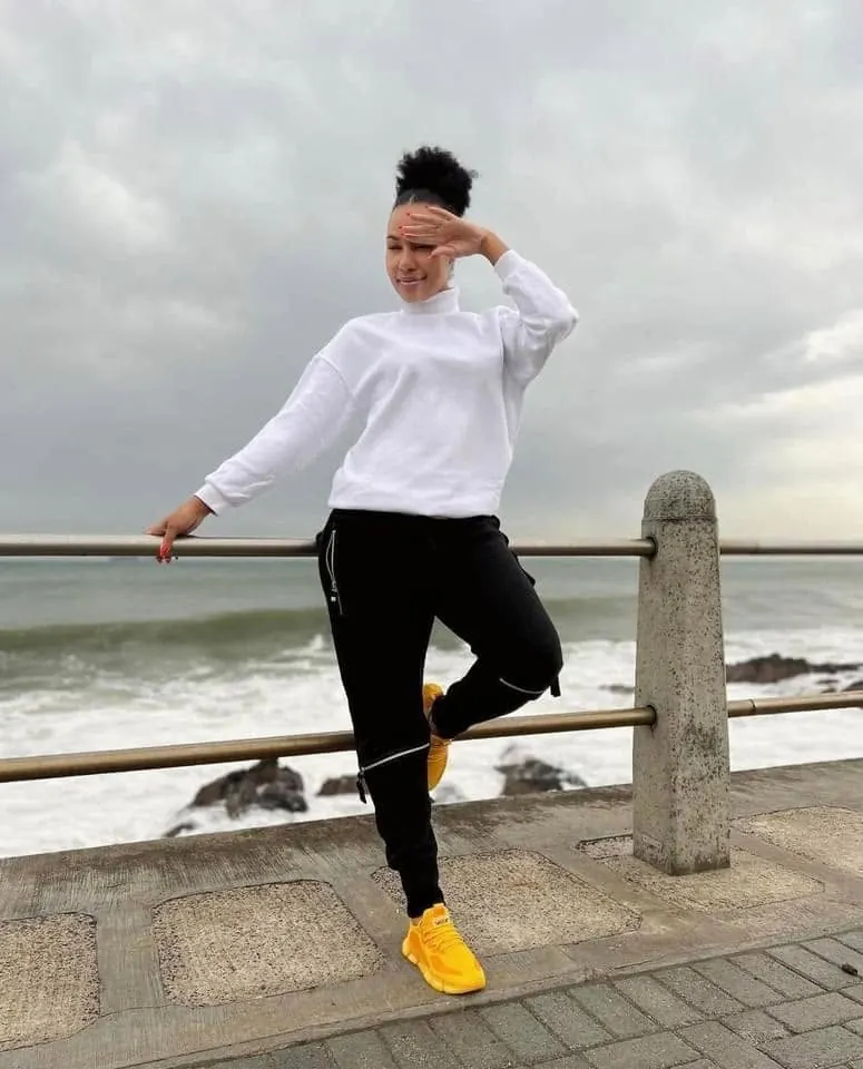 VAYA Mustard sneakers worn on a seaside promenade