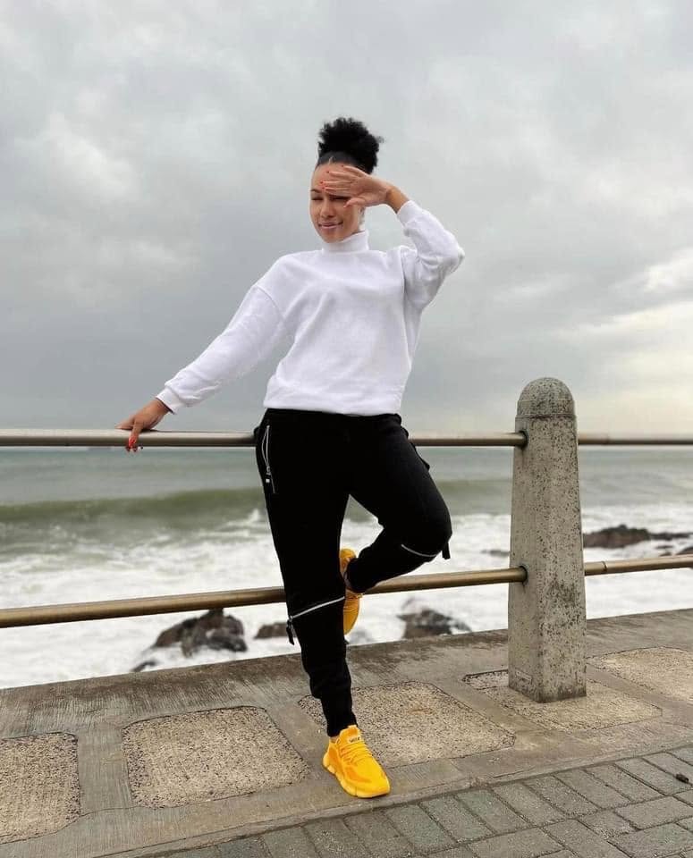 VAYA Mustard sneakers worn on a seaside promenade
